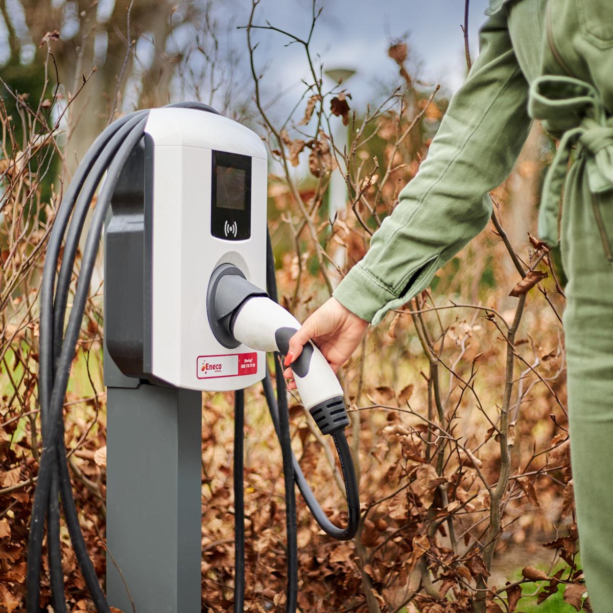 Woman grabbing a cable to charge her electric vehicle